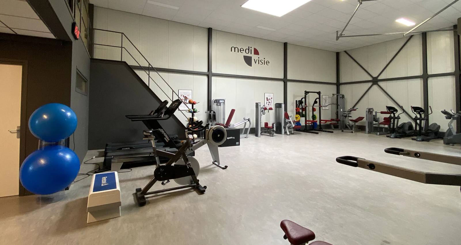 De eigen medische trainingsruimte van Medivisie in Almere met loopbanden, roeitrapper, krachtapparatuur en fitnesstoestellen